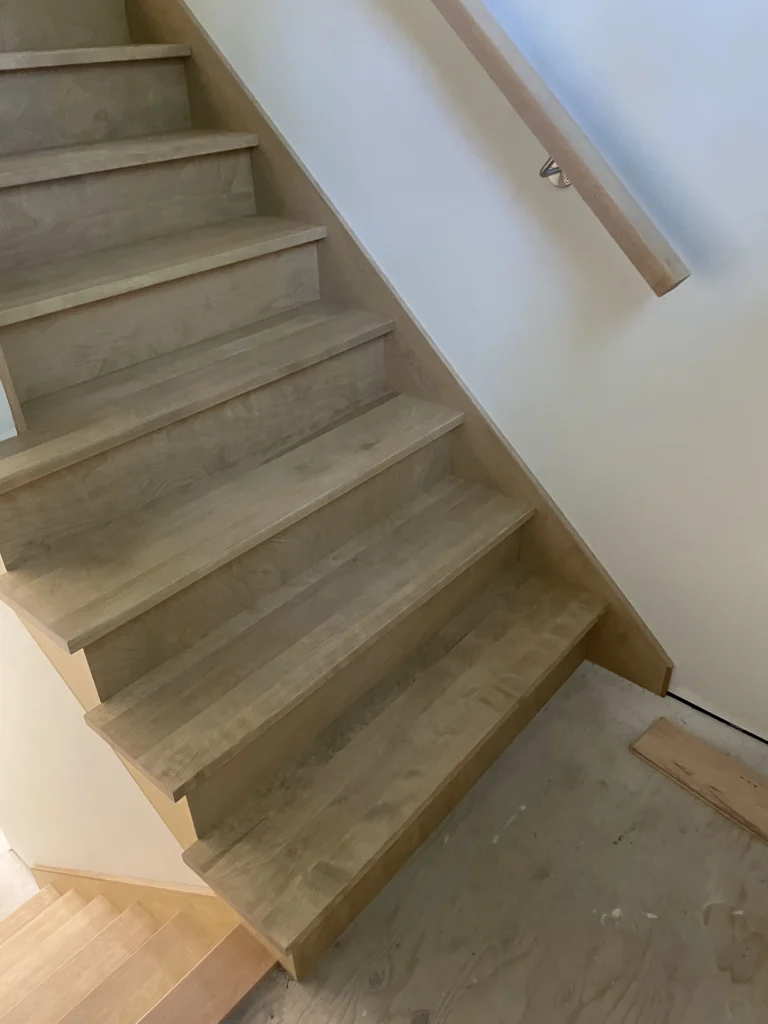 Volée de bois clair vue de biais, contremarches pleines, à Sherbrooke