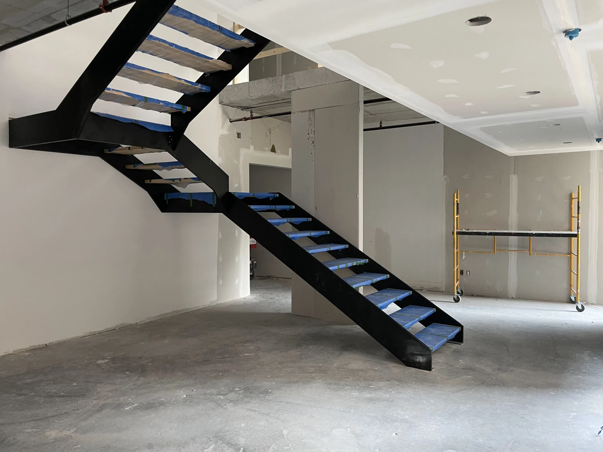Escalier tournant à limon central d&rsquo;acier noir sur deux volées — vue principale