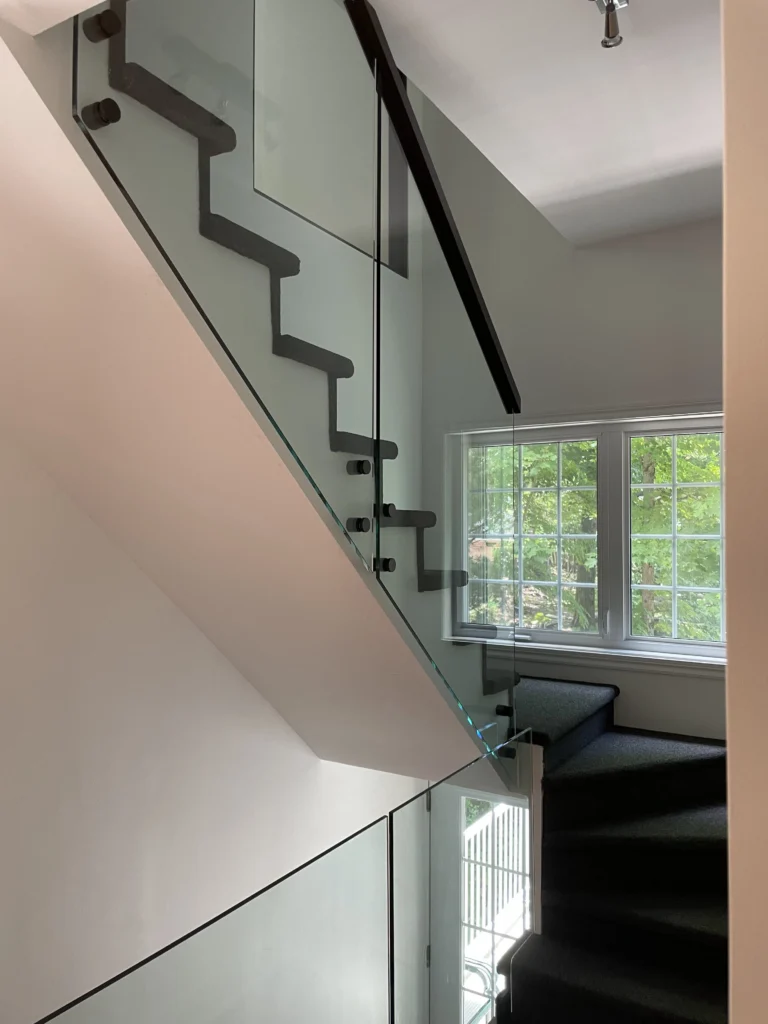 Escalier tournant au garde-corps de verre à pinces noires