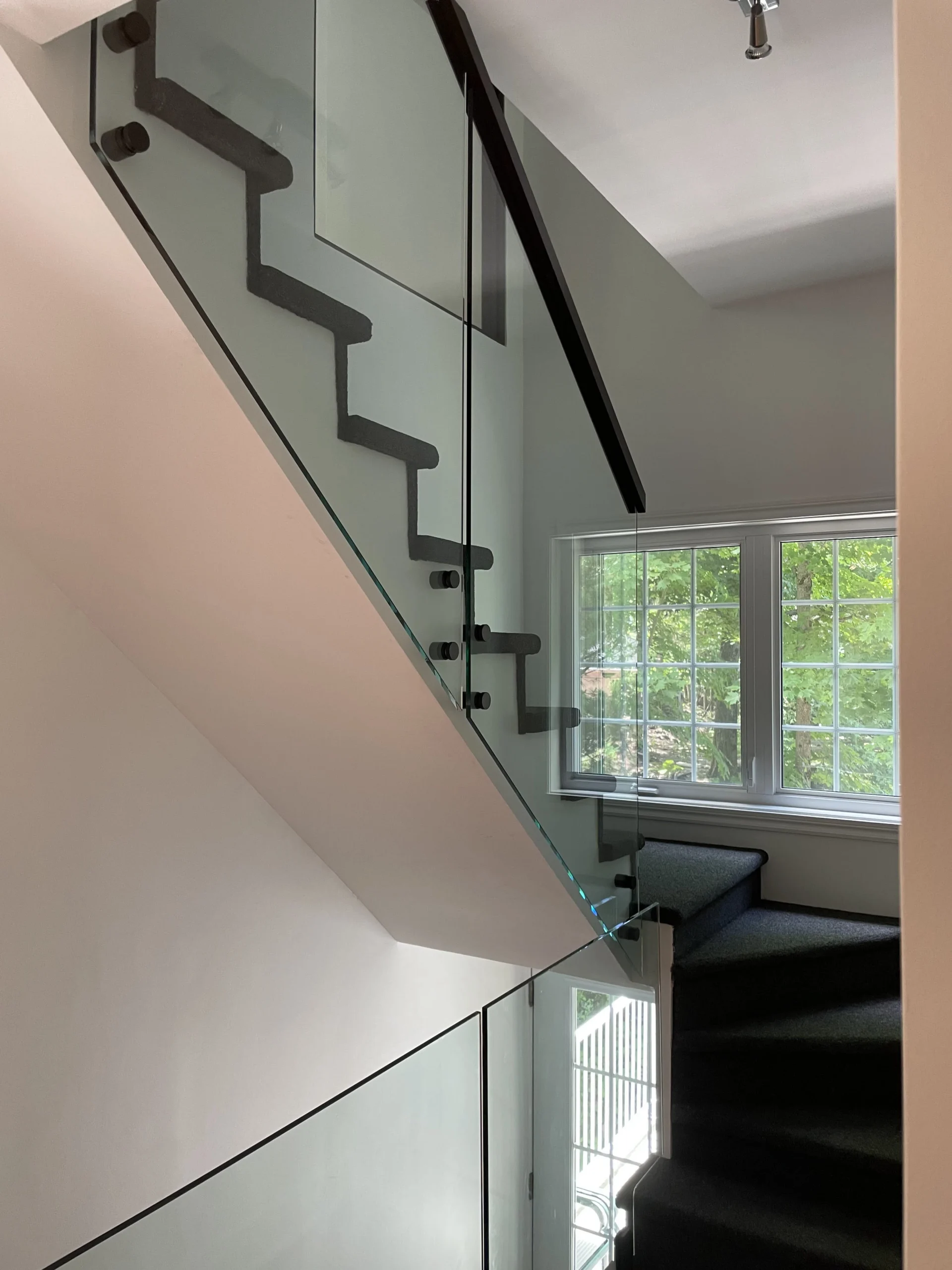 Escalier tournant au garde-corps de verre à pinces noires — vue principale