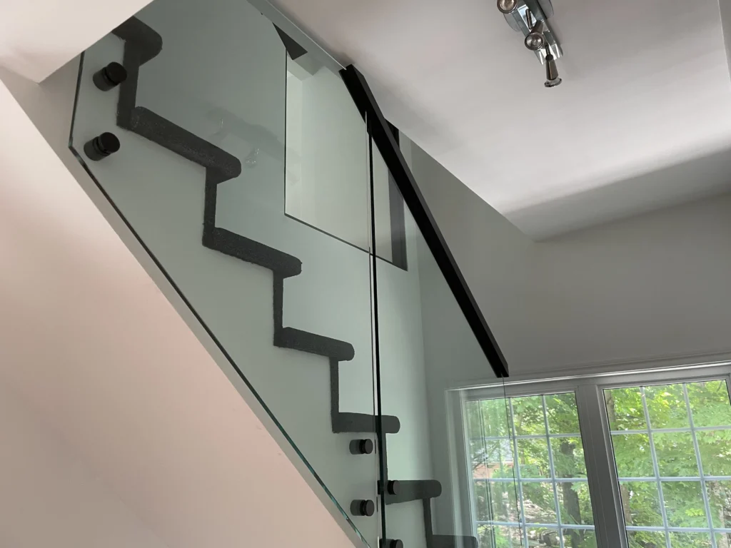 Panneaux de verre à pinces noires longeant l'escalier
