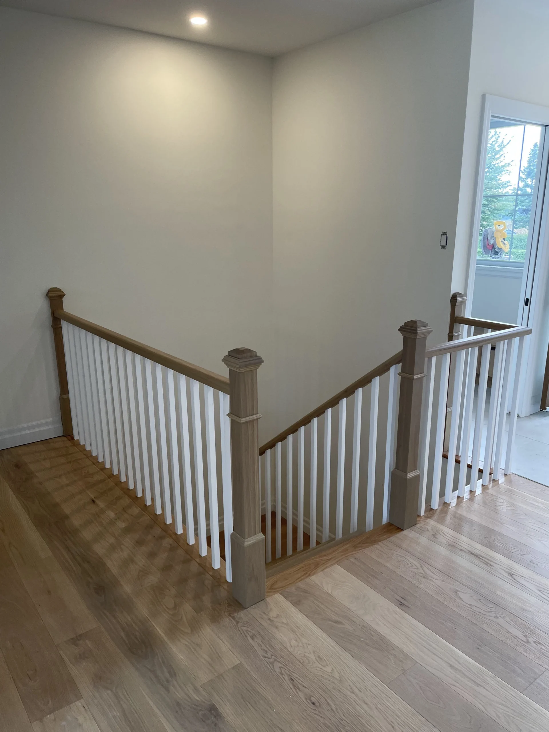 Escalier tournant en chêne à barreaux blancs sur plusieurs paliers — vue principale