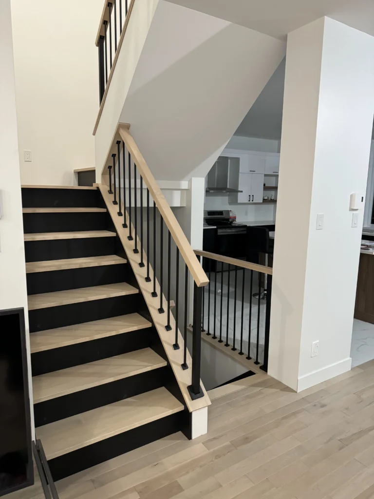 Escalier tournant en érable à contremarches noires et barreaux métalliques