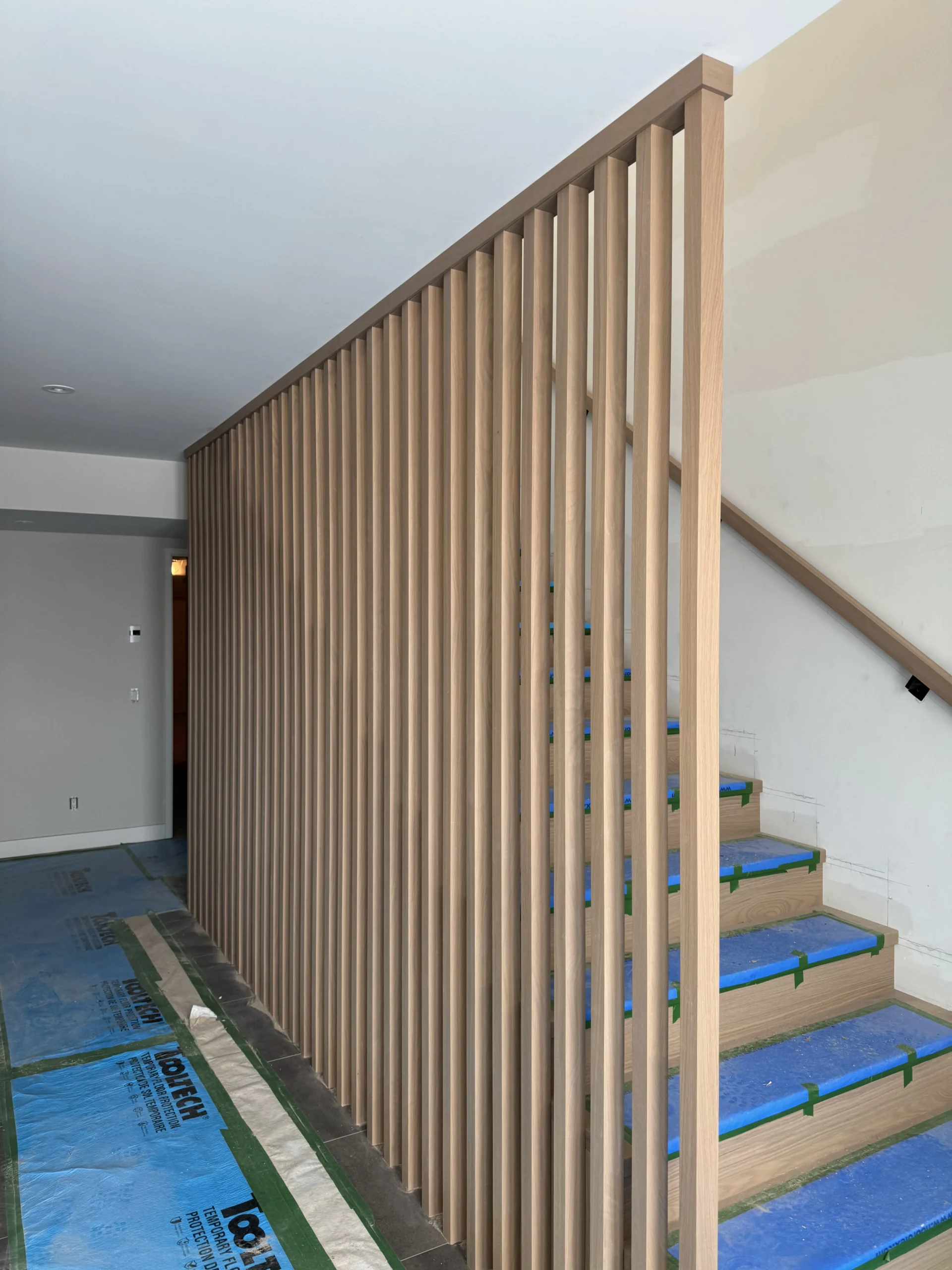 Escalier droit habillé d&rsquo;un claustra de tasseaux verticaux en chêne blanc — vue principale