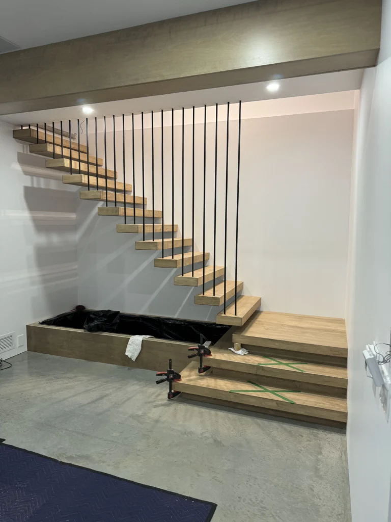 Escalier suspendu en chêne à marches flottantes et garde-corps de tiges noires