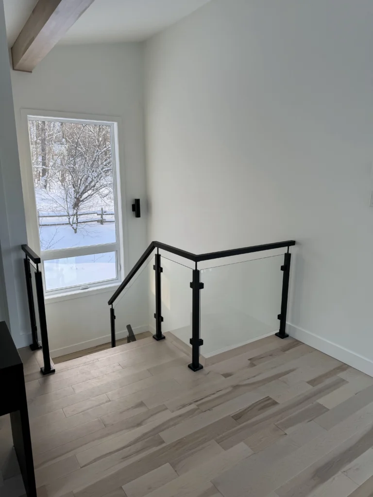 Palier vitré de l'escalier avec poteaux métalliques noirs