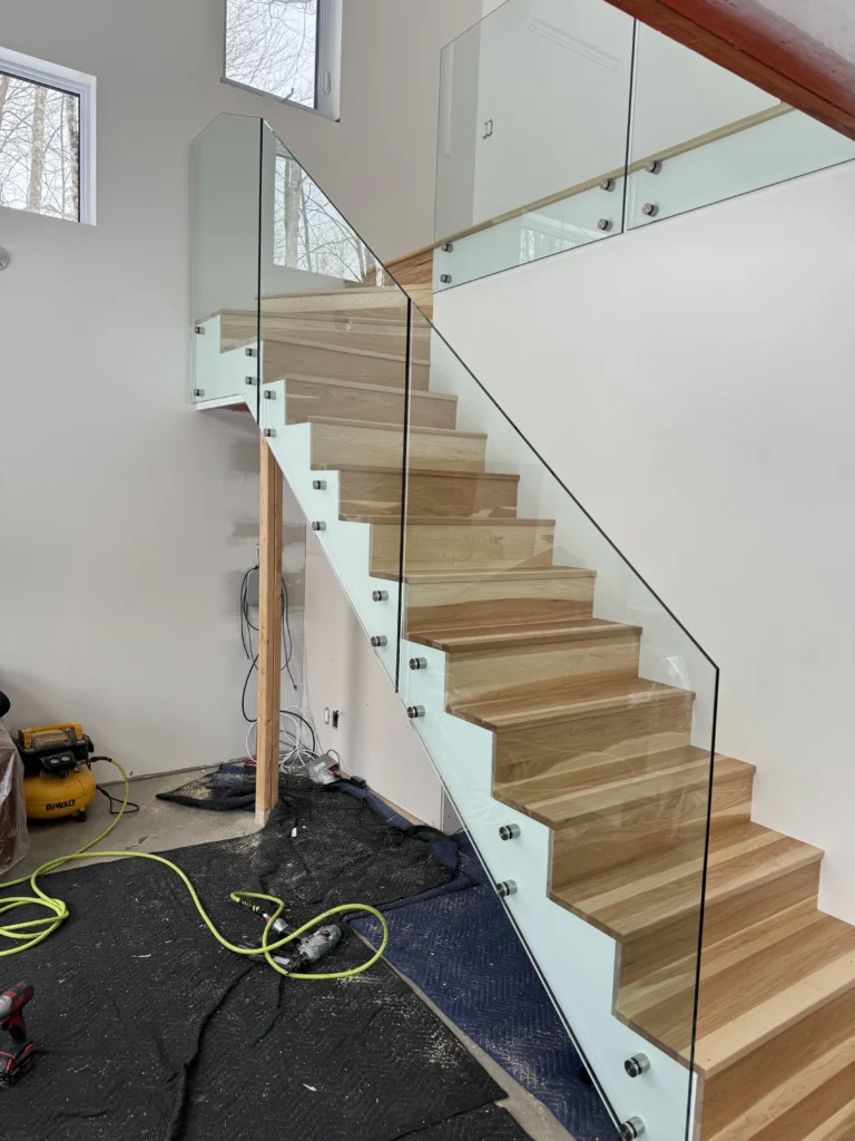 Escalier tournant en chêne blanc à contremarches ouvertes et garde-corps de verre
