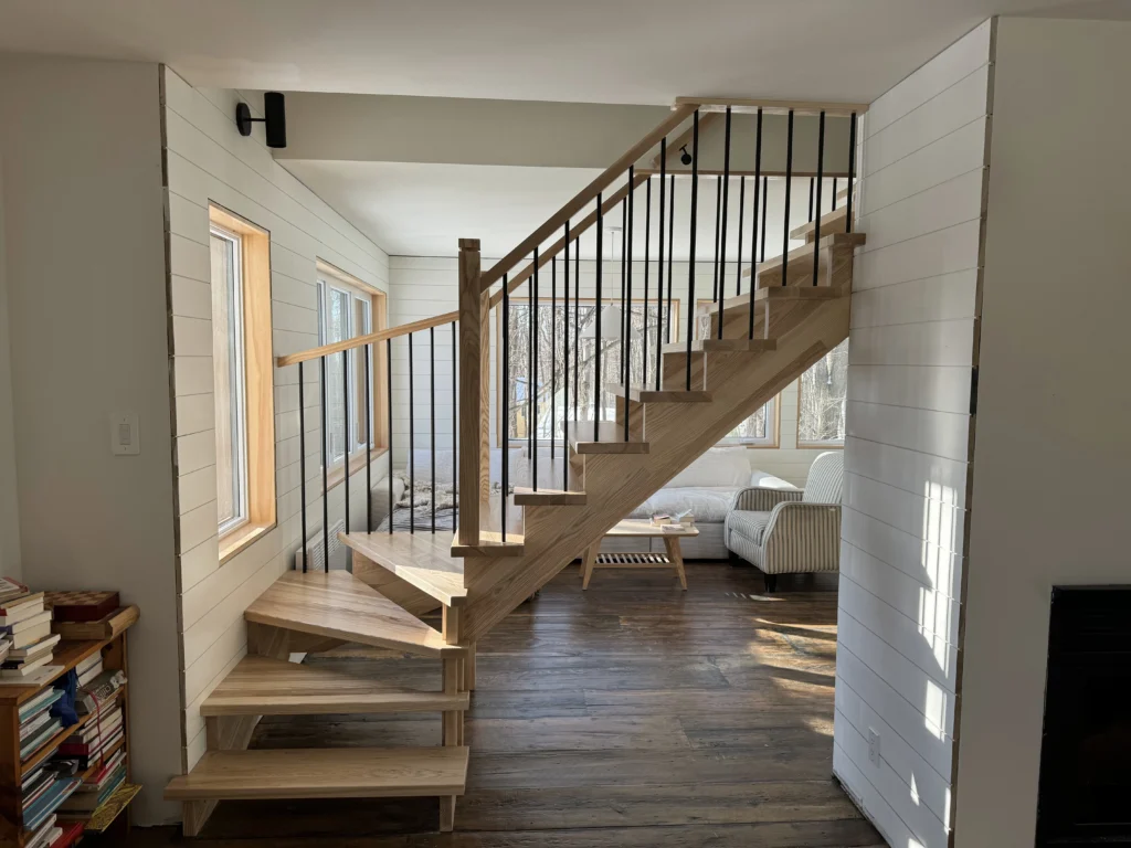 Escalier tournant en frêne naturel à marches rayonnantes et barreaux métalliques