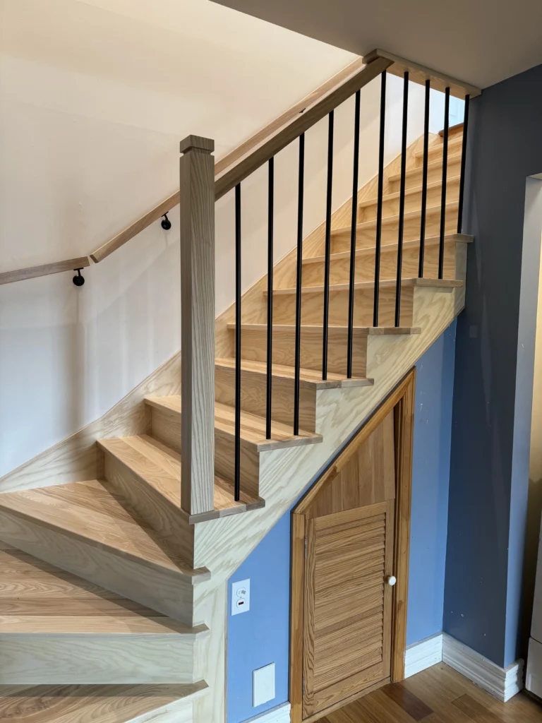 Volée de l'escalier en frêne avec barreaux métalliques noirs