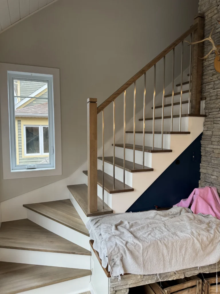 Escalier tournant en bois teinté gris à barreaux métalliques