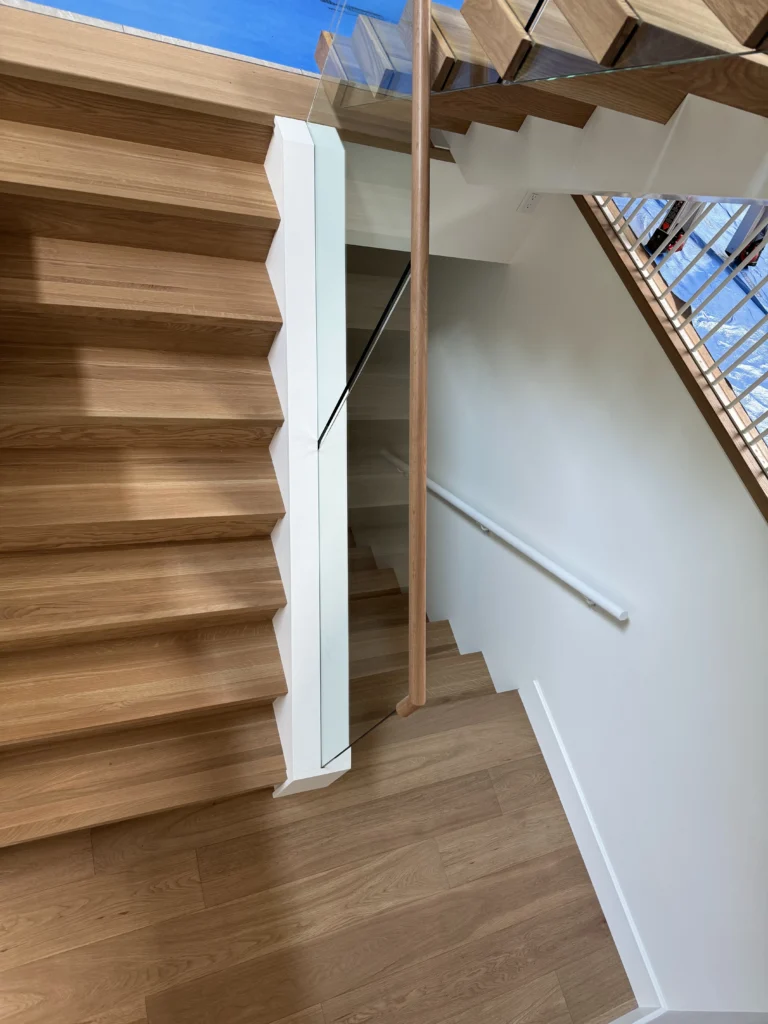 Escalier tournant en chêne blond à garde-corps de verre