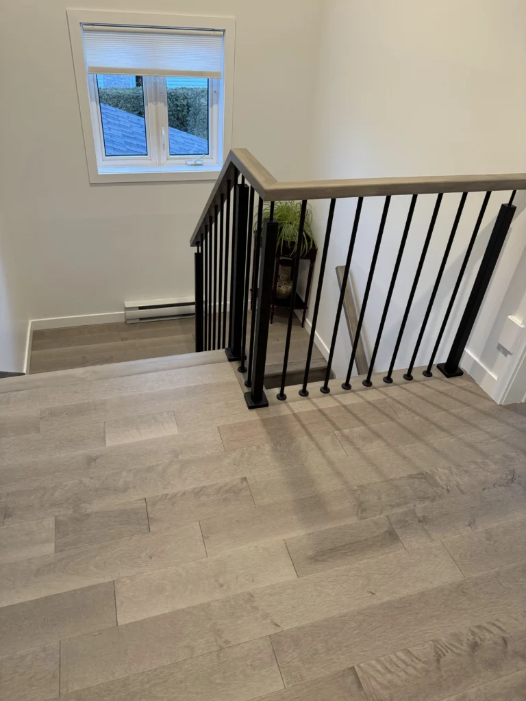 Escalier tournant en érable teinté gris à barreaux d&rsquo;acier noir