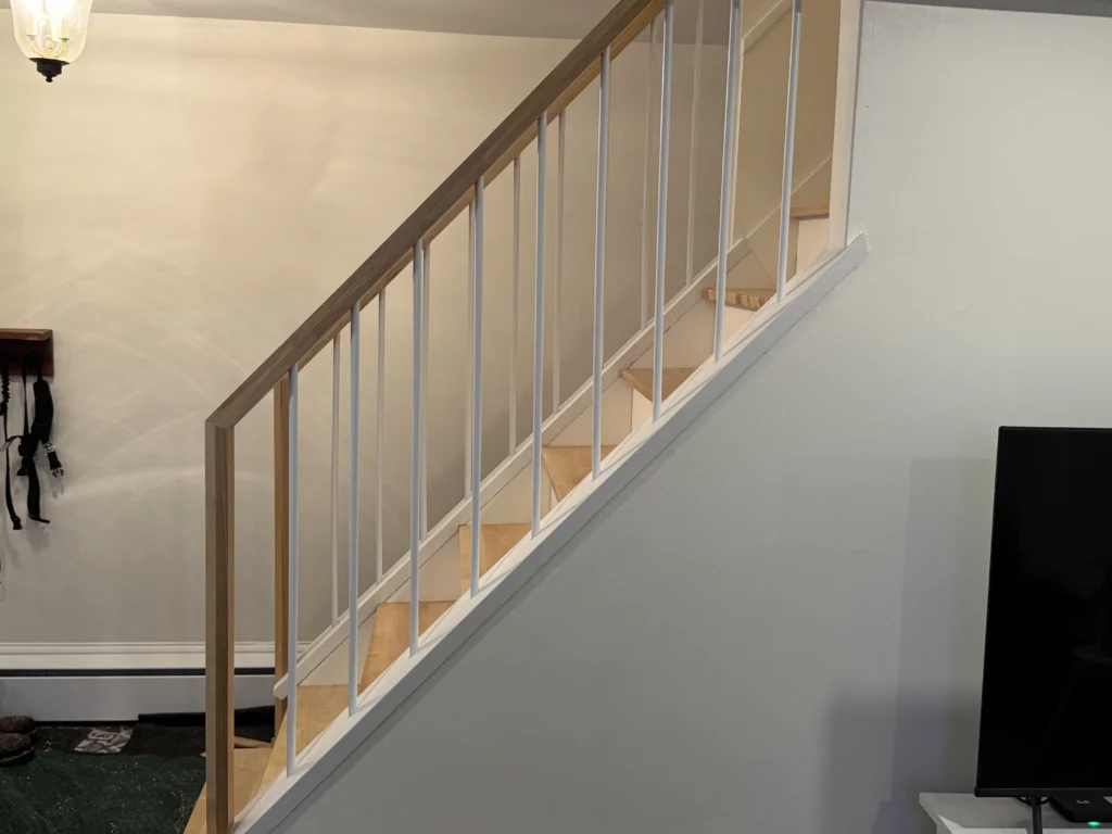 Garde-corps de bois clair et de barreaux blancs de l'escalier droit