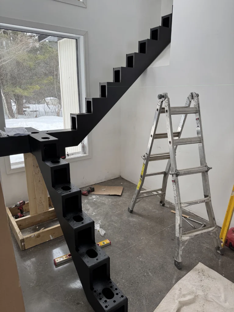 Escalier à limon central d&rsquo;acier noir en cours d&rsquo;installation