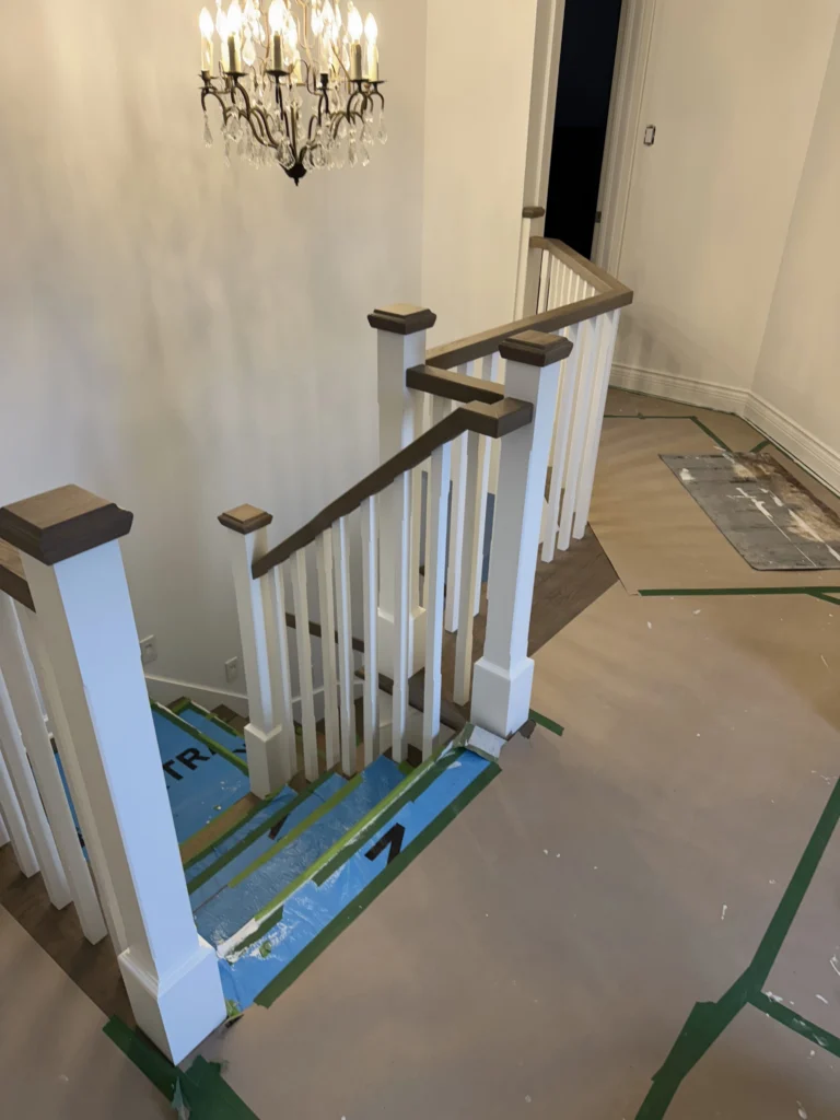 Escalier tournant à barreaux blancs et main courante de chêne teinté