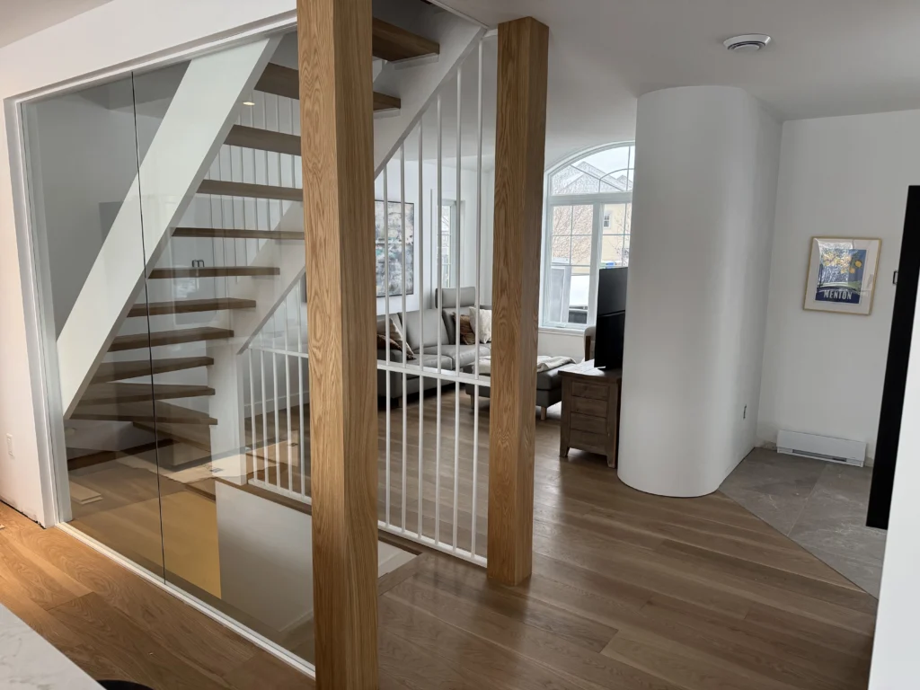 Escalier vu à travers la paroi de verre, salon à l'arrière-plan