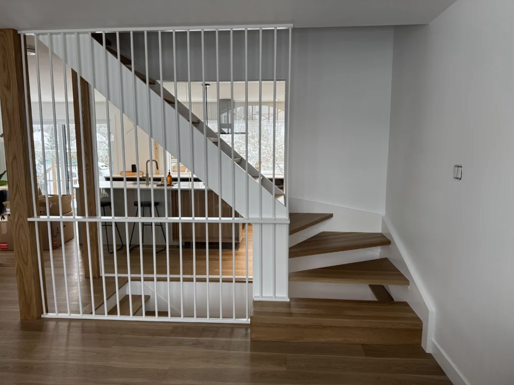 Escalier et grande fenêtre cintrée du salon