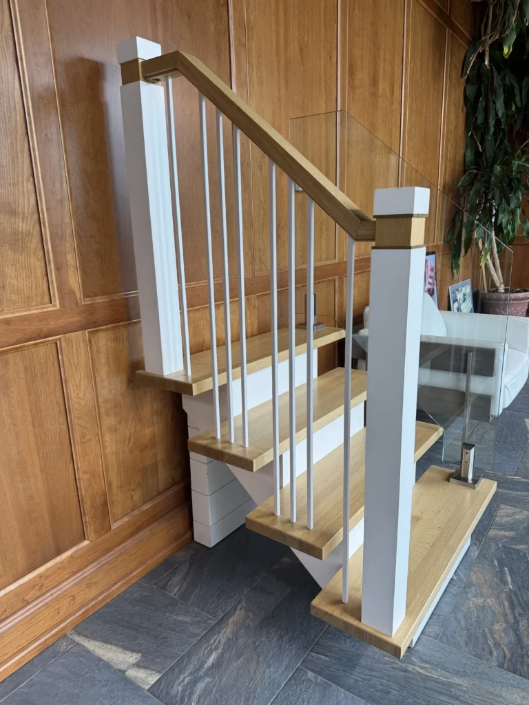 Escalier tournant à barreaux métalliques et verre sur boiserie de bois