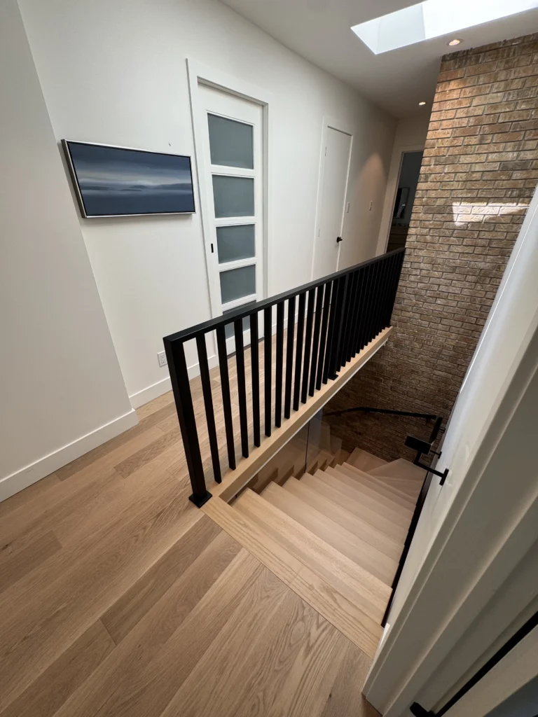 Escalier tournant en chêne blanc à garde-corps de métal noir