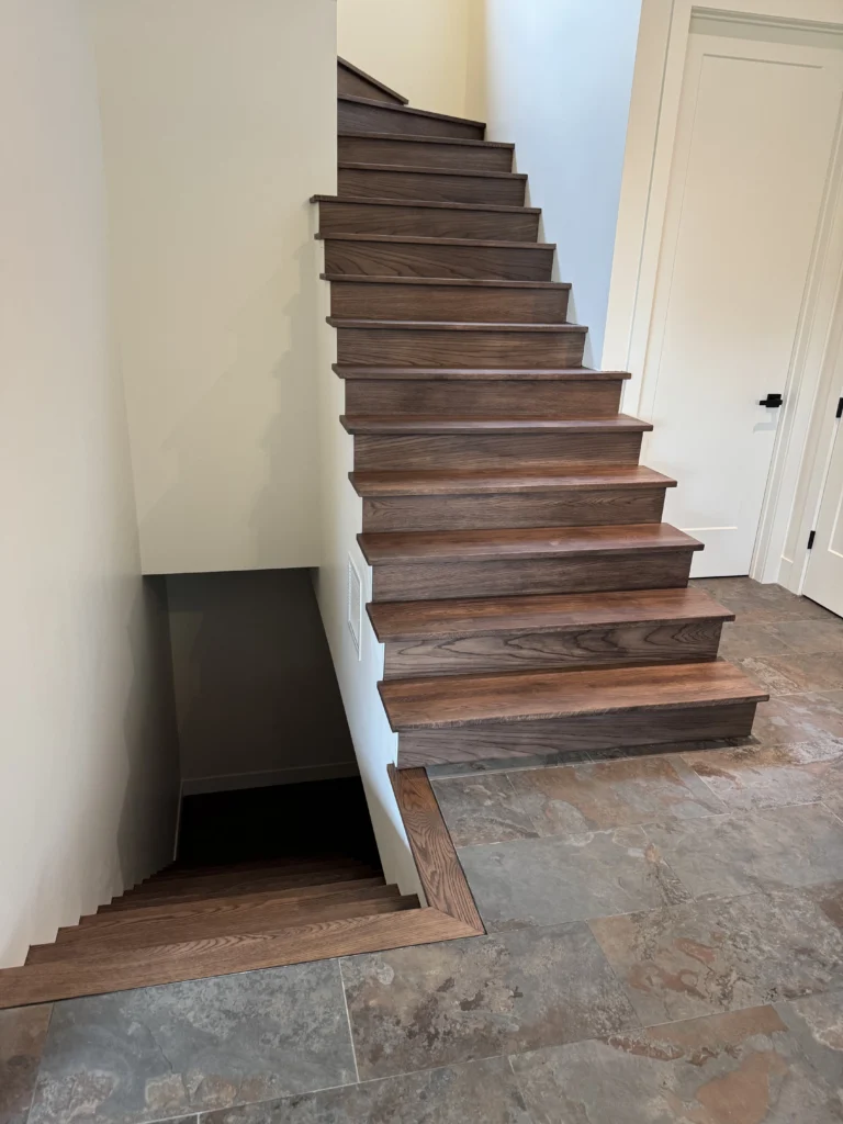 Escalier droit en bois franc teinté noyer sur plancher d&rsquo;ardoise