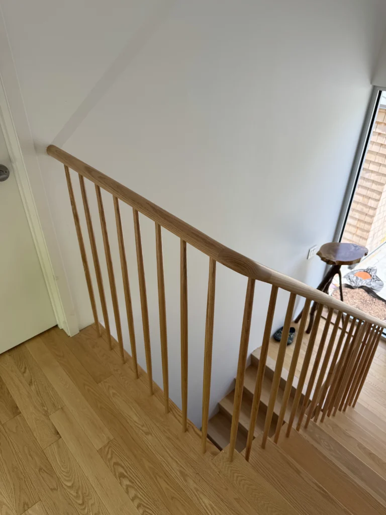 Escalier tournant à barreaux de bois tournés et main courante arrondie