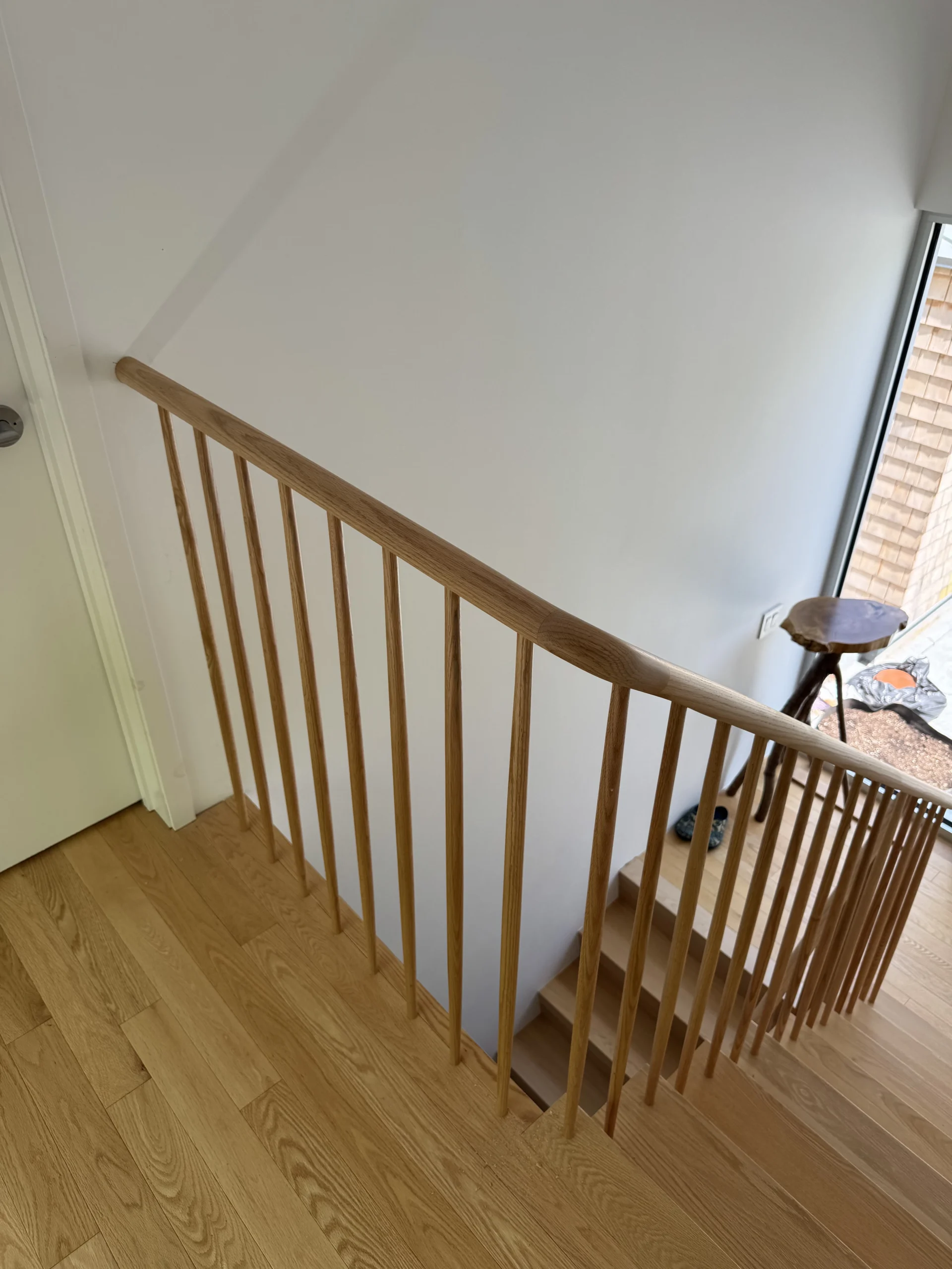 Escalier tournant à barreaux de bois tournés et main courante arrondie — vue principale