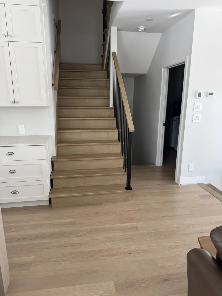 Escalier droit en chêne blanc à barreaux d&rsquo;acier noir et cuisine attenante
