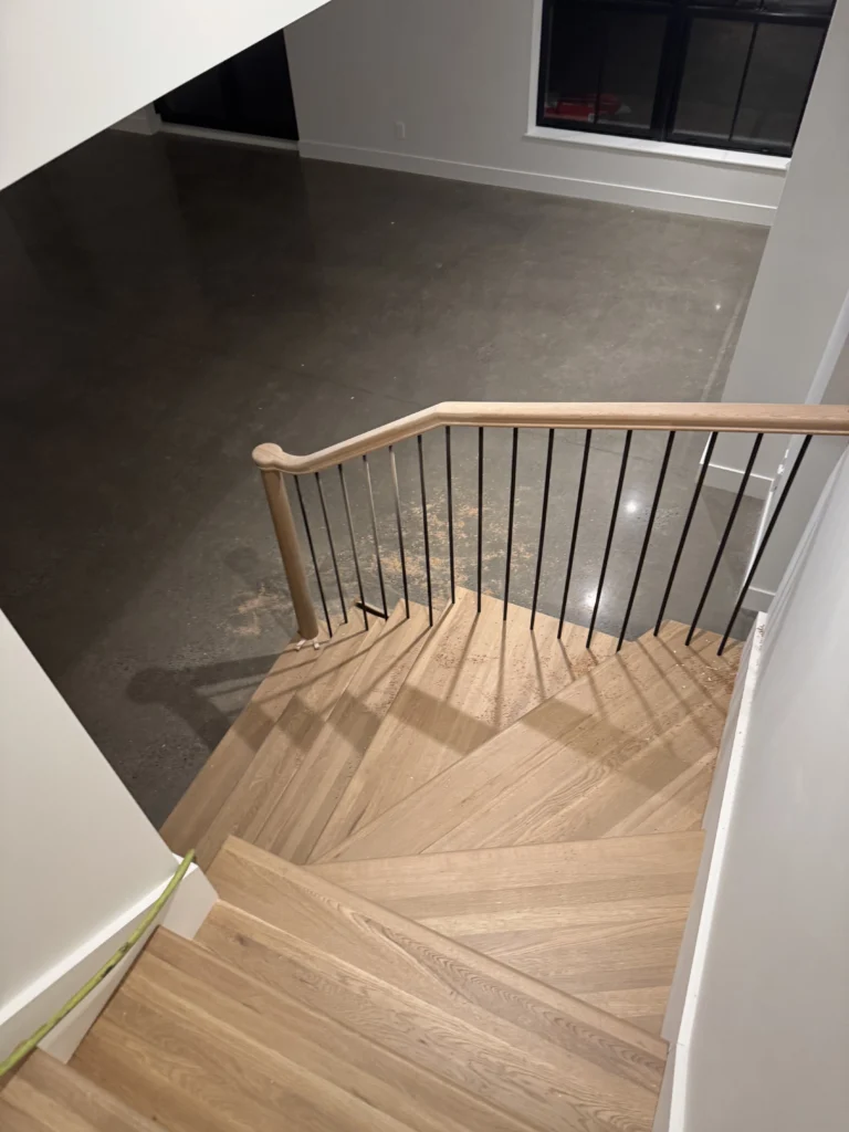 Escalier tournant en chêne blond à barreaux métalliques noirs