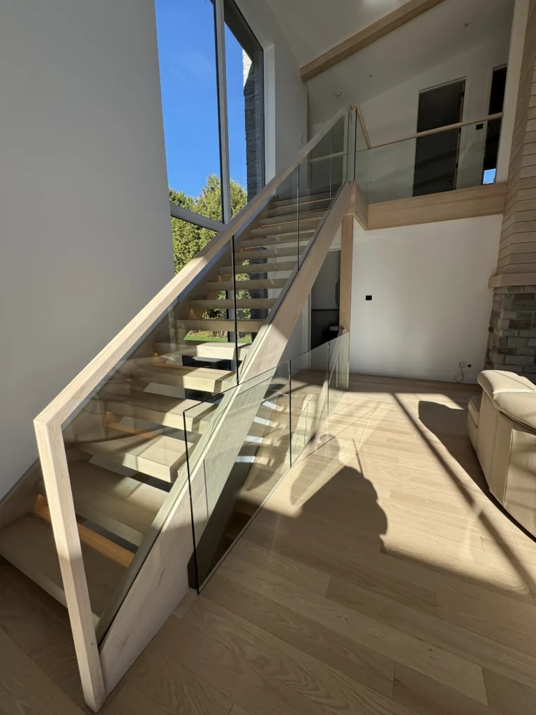 Escalier suspendu en chêne blanchi à garde-corps de verre