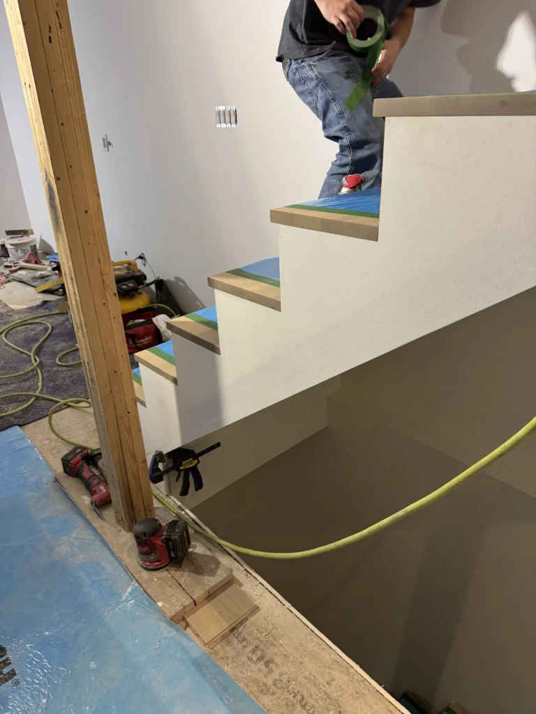 Escalier droit à limons blancs et marches de bois en cours d&rsquo;installation
