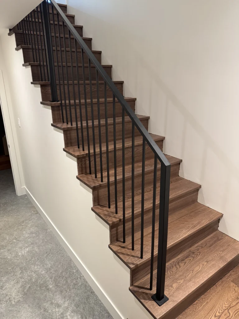 Escalier droit en chêne brun à garde-corps tout en métal noir