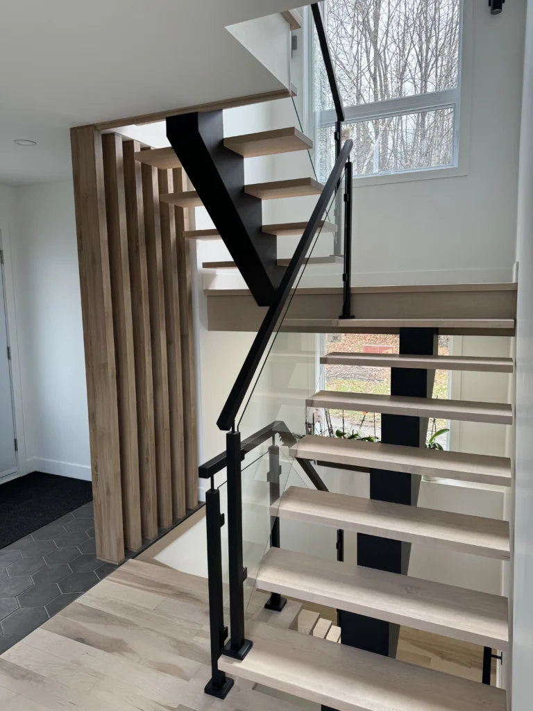 Escalier suspendu à limon central d&rsquo;acier, verre et claustra de bois