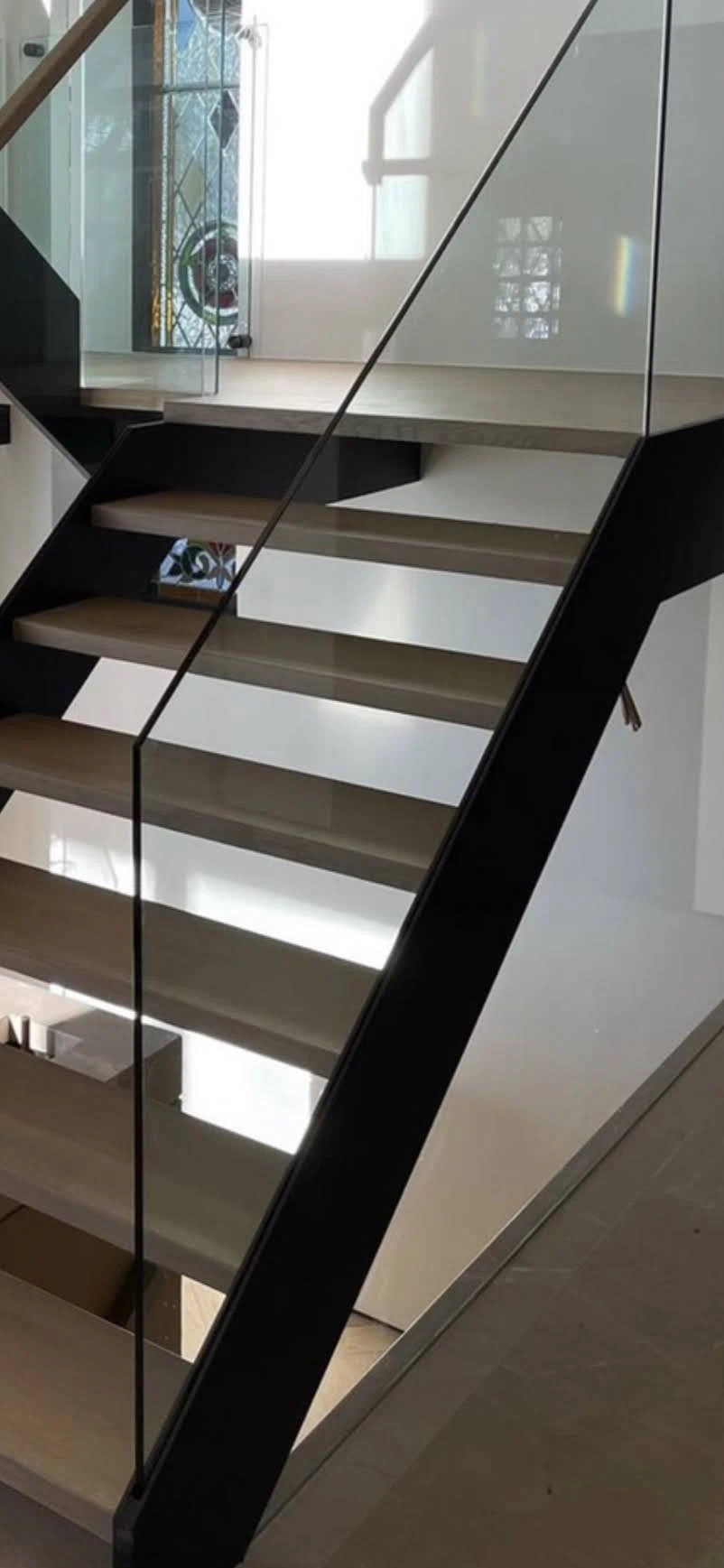 Escalier suspendu à marches de chêne et garde-corps de verre sans cadre — vue principale
