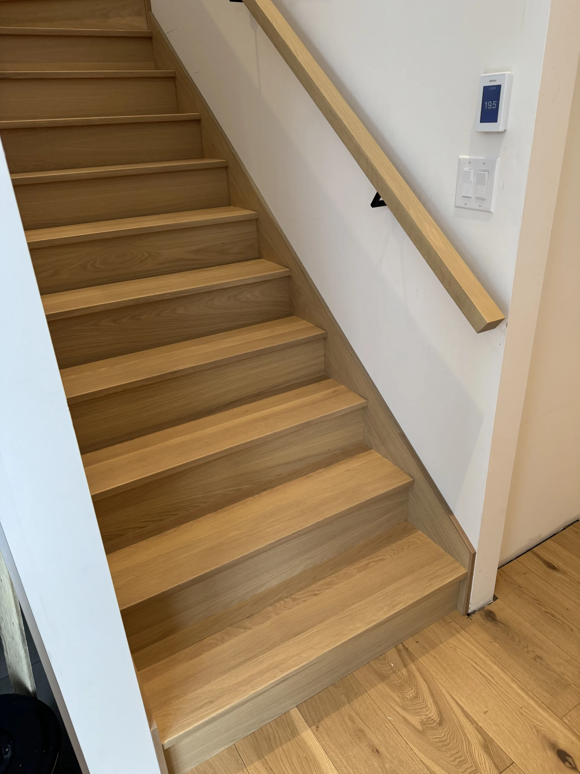 Escalier droit en chêne blanc entre deux murs à main courante murale — vue principale