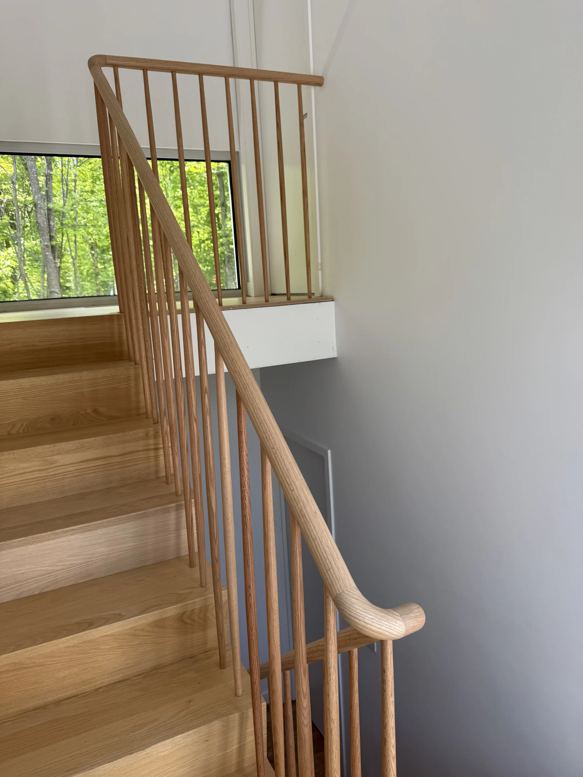 Escalier tournant en frêne à barreaux ronds et main courante sculptée — vue principale
