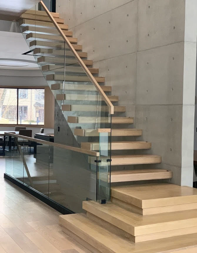 Escalier suspendu en chêne blanc ancré à un mur de béton