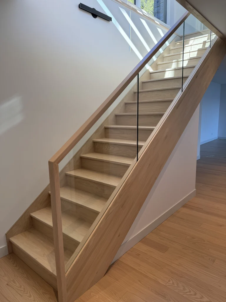 Escalier droit en chêne blanc à garde-corps de verre encadré de bois