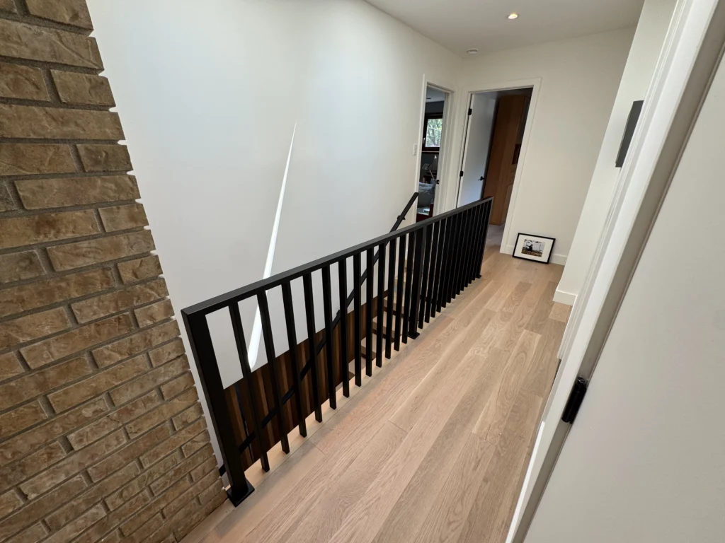 Garde-corps d&rsquo;escalier à barreaux d&rsquo;acier noir sur plancher de chêne