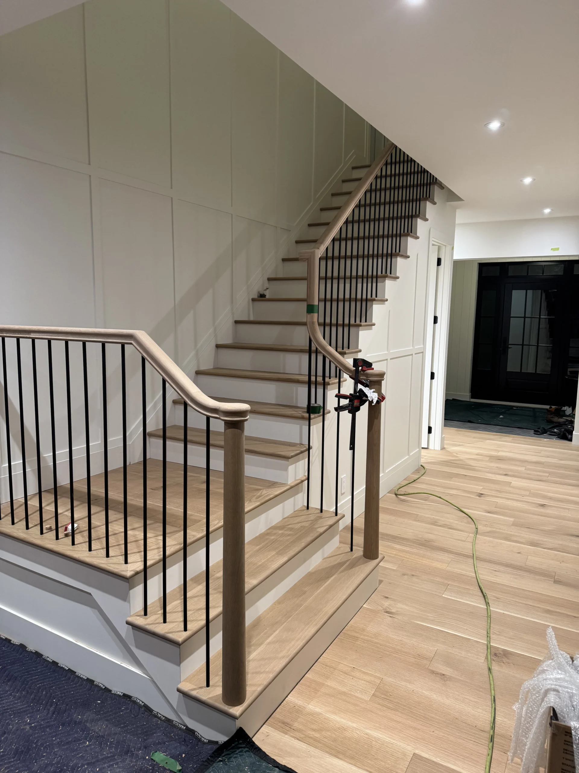 Escalier tournant en chêne blanc à barreaux de métal noir et poteaux de bois — vue principale