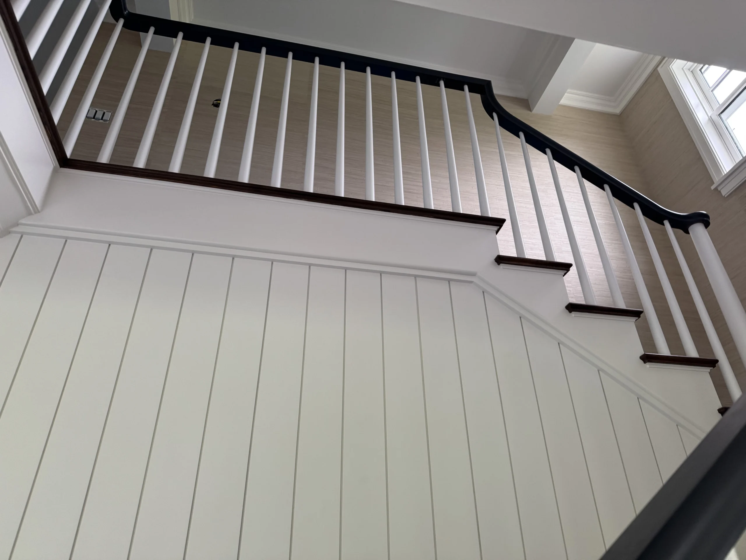Escalier tournant classique à balustres blancs et main courante en bois foncé — vue principale