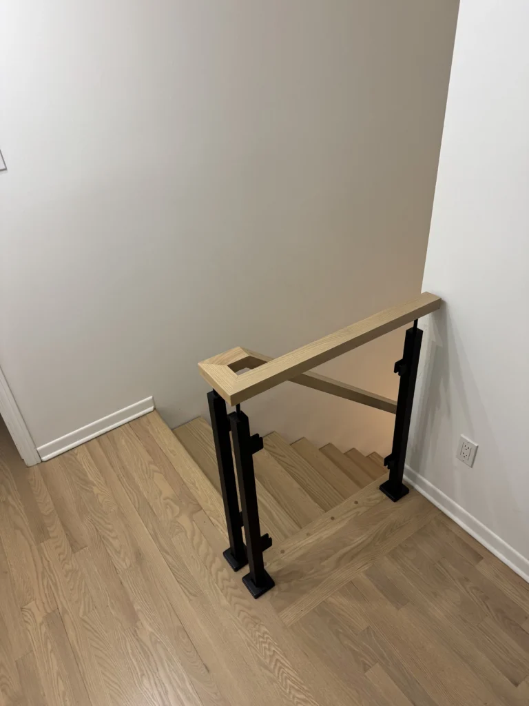 Garde-corps de trémie minimaliste en bois blond et poteaux noirs