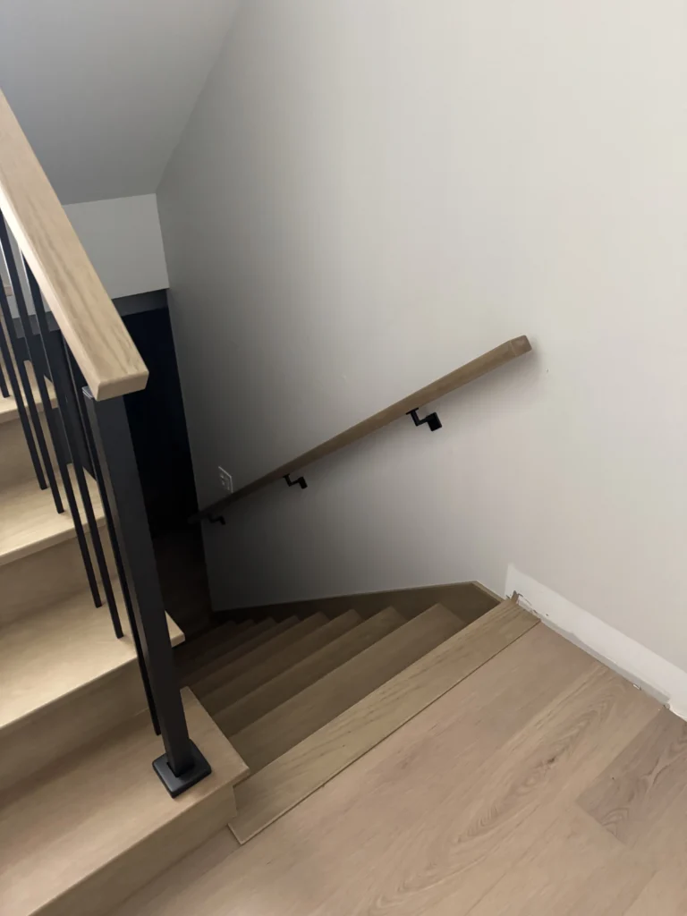 Escalier tournant en chêne blanchi à barreaux métalliques noirs