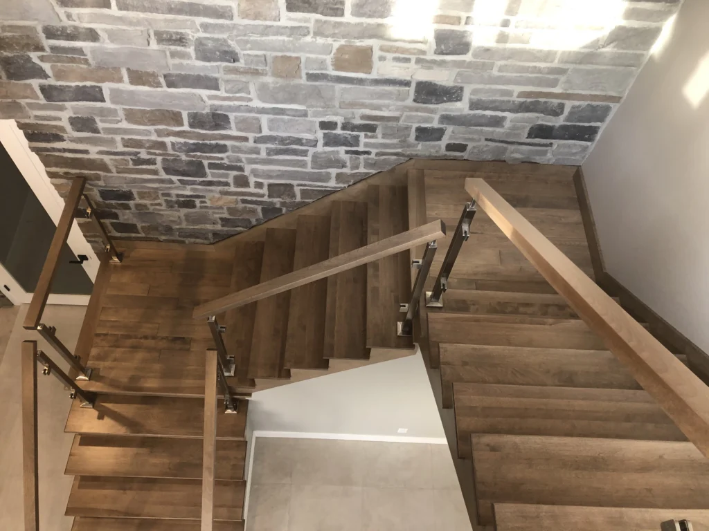 Escalier à demi-tour en bois gris-brun, verre et acier inoxydable