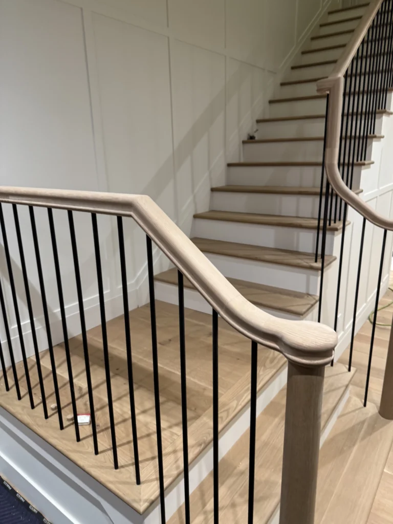 Escalier tournant en chêne blanchi à fins barreaux noirs