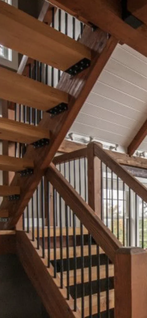 Escalier tournant en chêne à contremarches ouvertes et barreaux métalliques noirs
