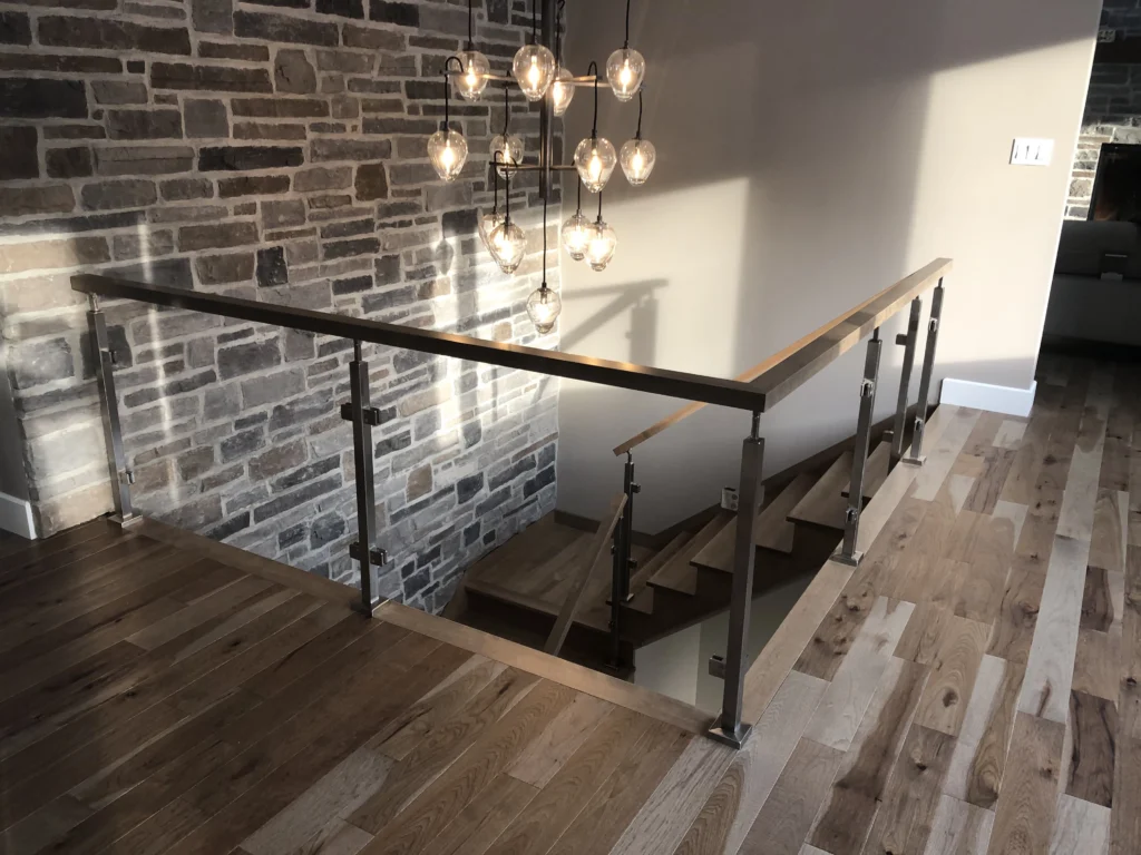 Escalier droit avec garde-corps de verre, poteaux d&rsquo;acier inoxydable et main courante de bois