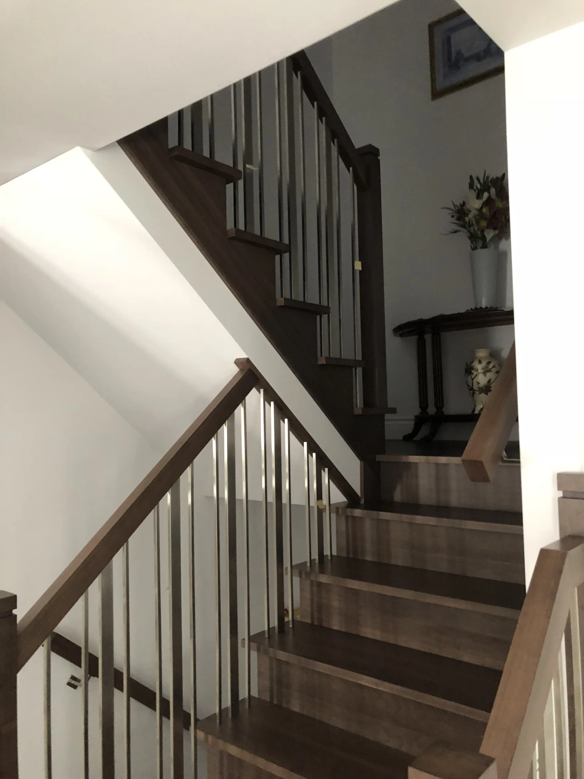 Escalier tournant en bois teinté brun foncé avec barreaux nickelés brossés — vue principale