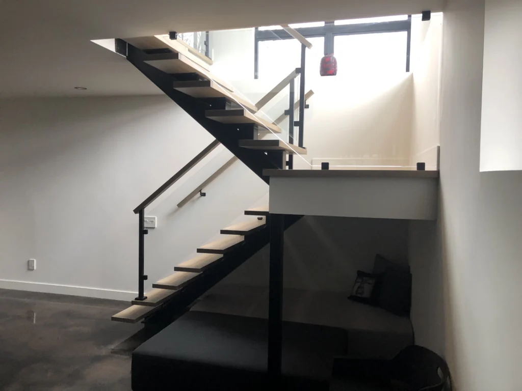 Escalier suspendu à limon d&rsquo;acier noir et marches de bois pâle