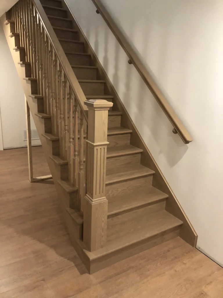 Escalier droit en bois blond à barreaux tournés et gros poteau cannelé