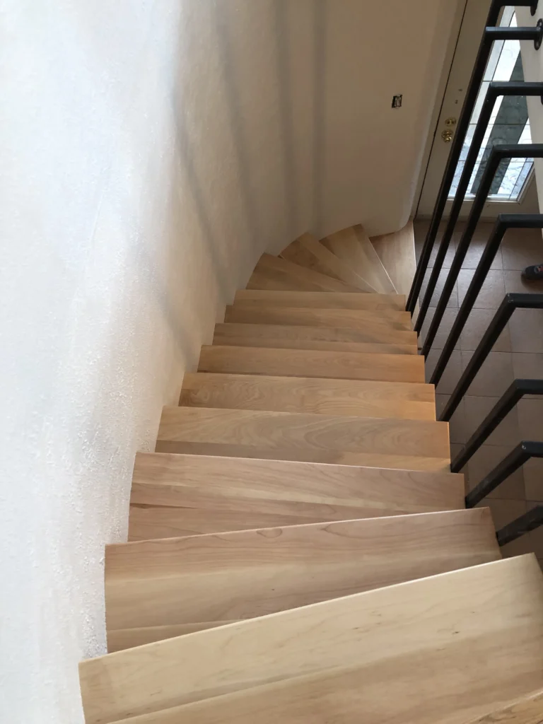 Escalier tournant à marches rayonnantes en bois brut